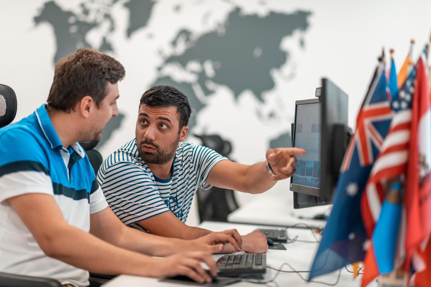 Group of Casual business man working on desktop computer in modern open plan startup office interior. Selective focus photo
