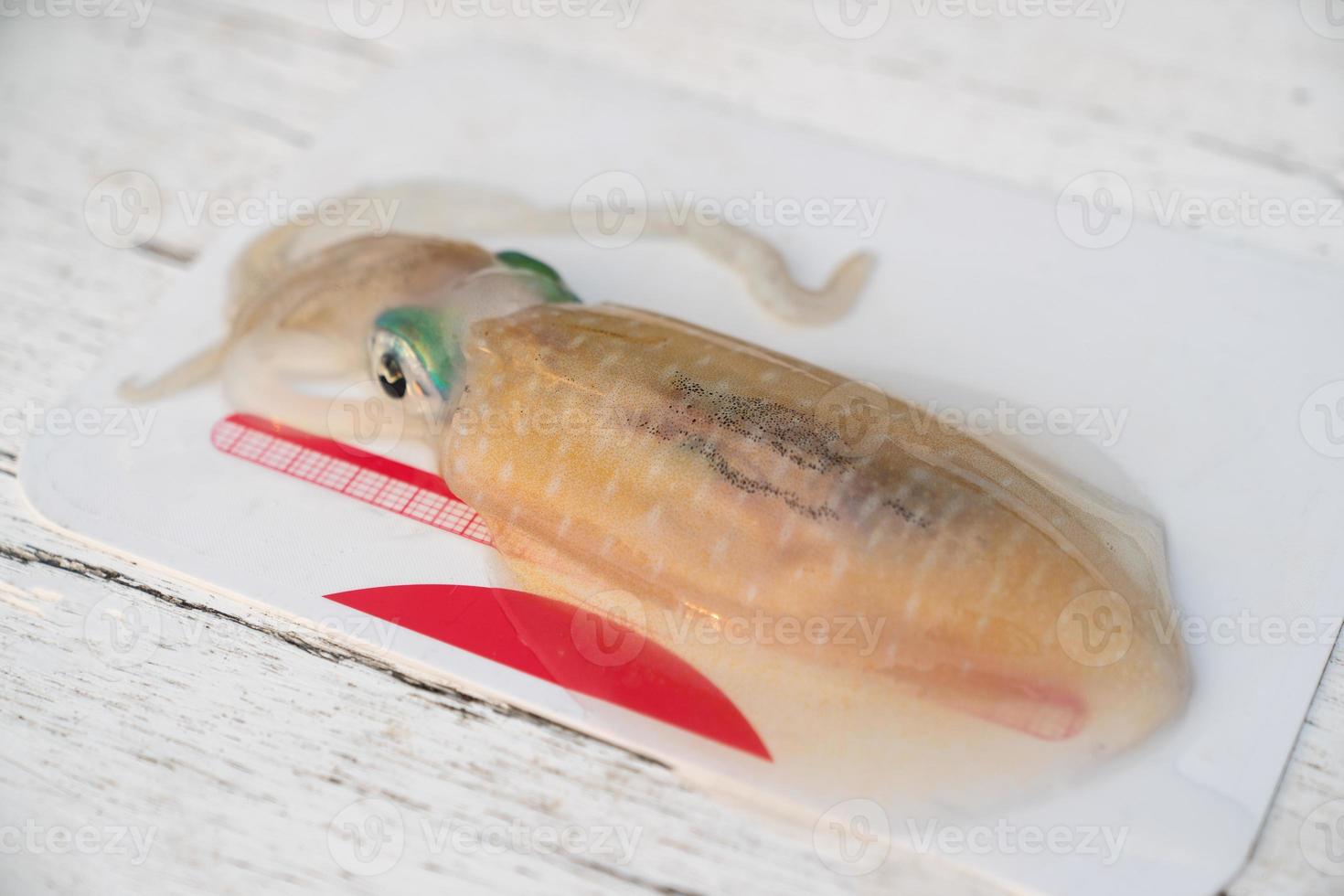 Preparation of raw squid on cutting board. photo