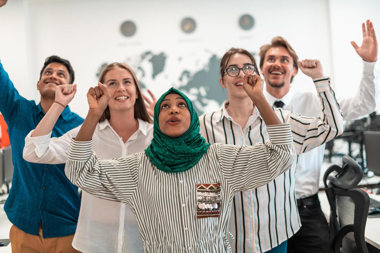 Portrait of young excited multiethnics business team of software developers standing and looking at camera at modern startup office photo