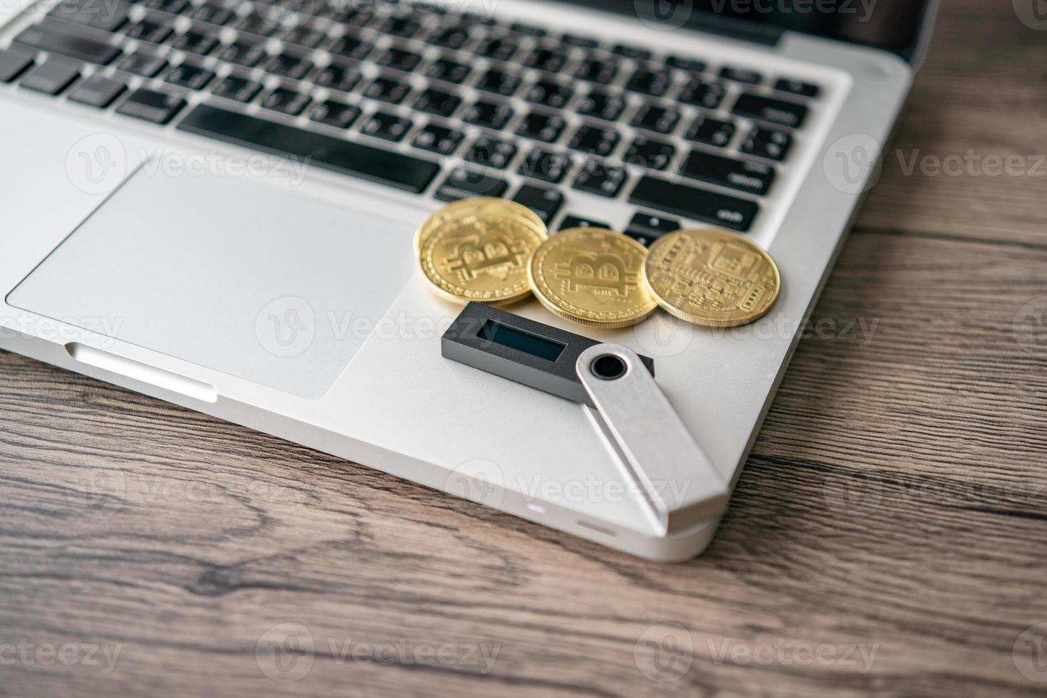 billetera de criptomonedas de hardware con bitcoin dorado btc en la computadora. almacenamiento seguro para criptografía. foto