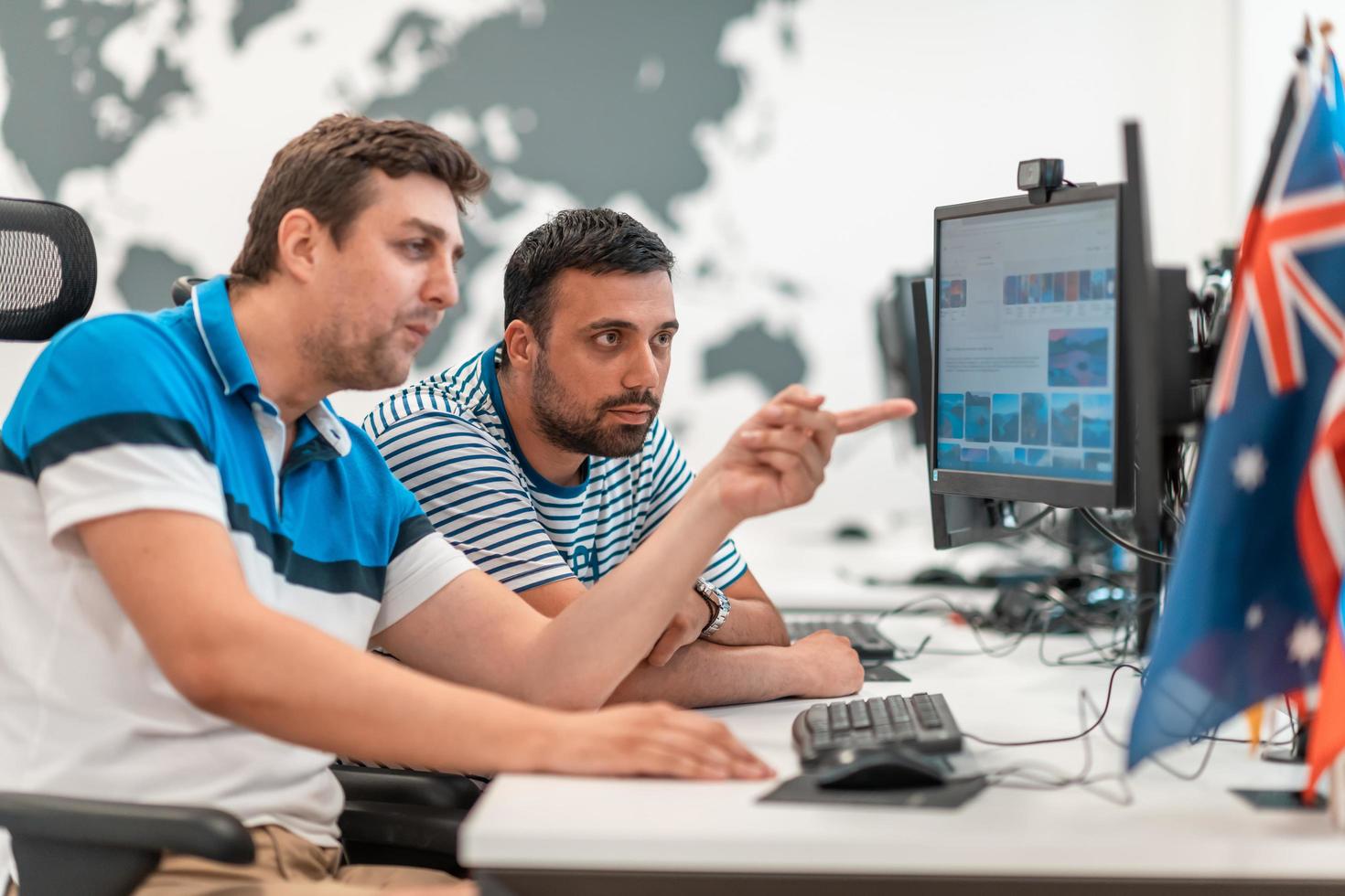 Group of Casual business man working on desktop computer in modern open plan startup office interior. Selective focus photo