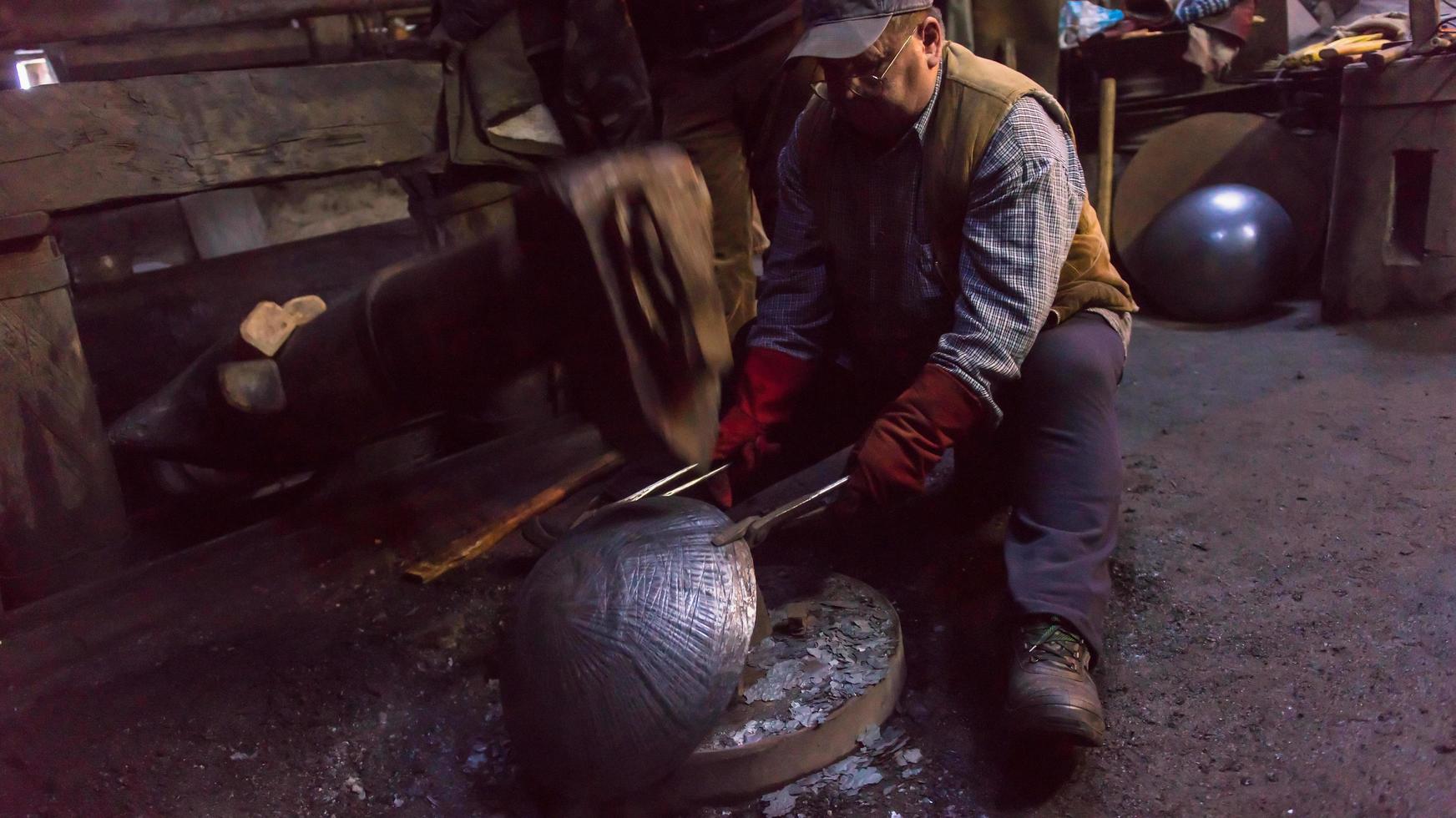 trabajadores del herrero que usan el martillo mecánico en el taller foto