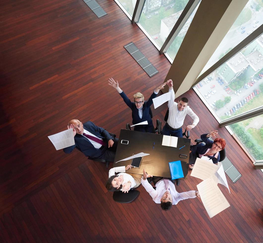 top view of business people group throwing dociments in air photo