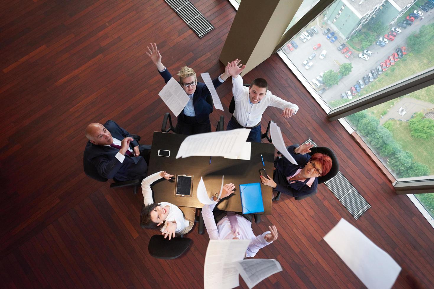 top view of business people group throwing dociments in air photo