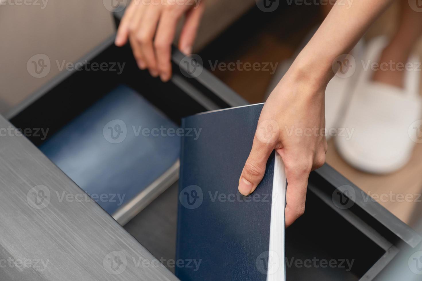 Woman hand with wooden drawer stand and note book inside. photo