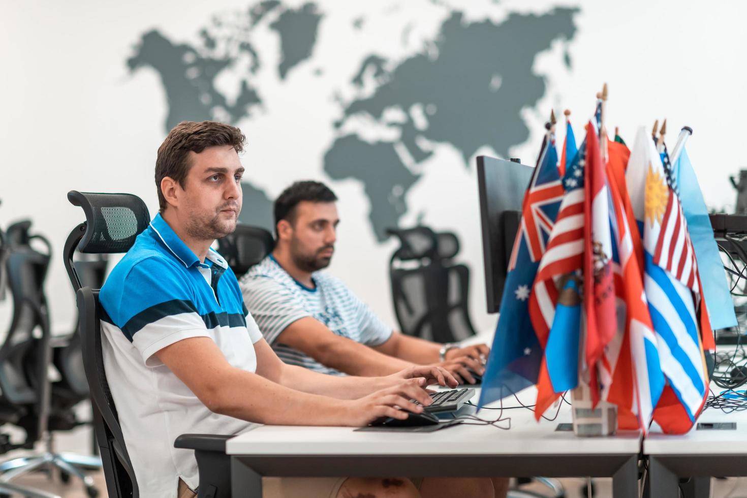 Group of Casual business man working on desktop computer in modern open plan startup office interior. Selective focus photo