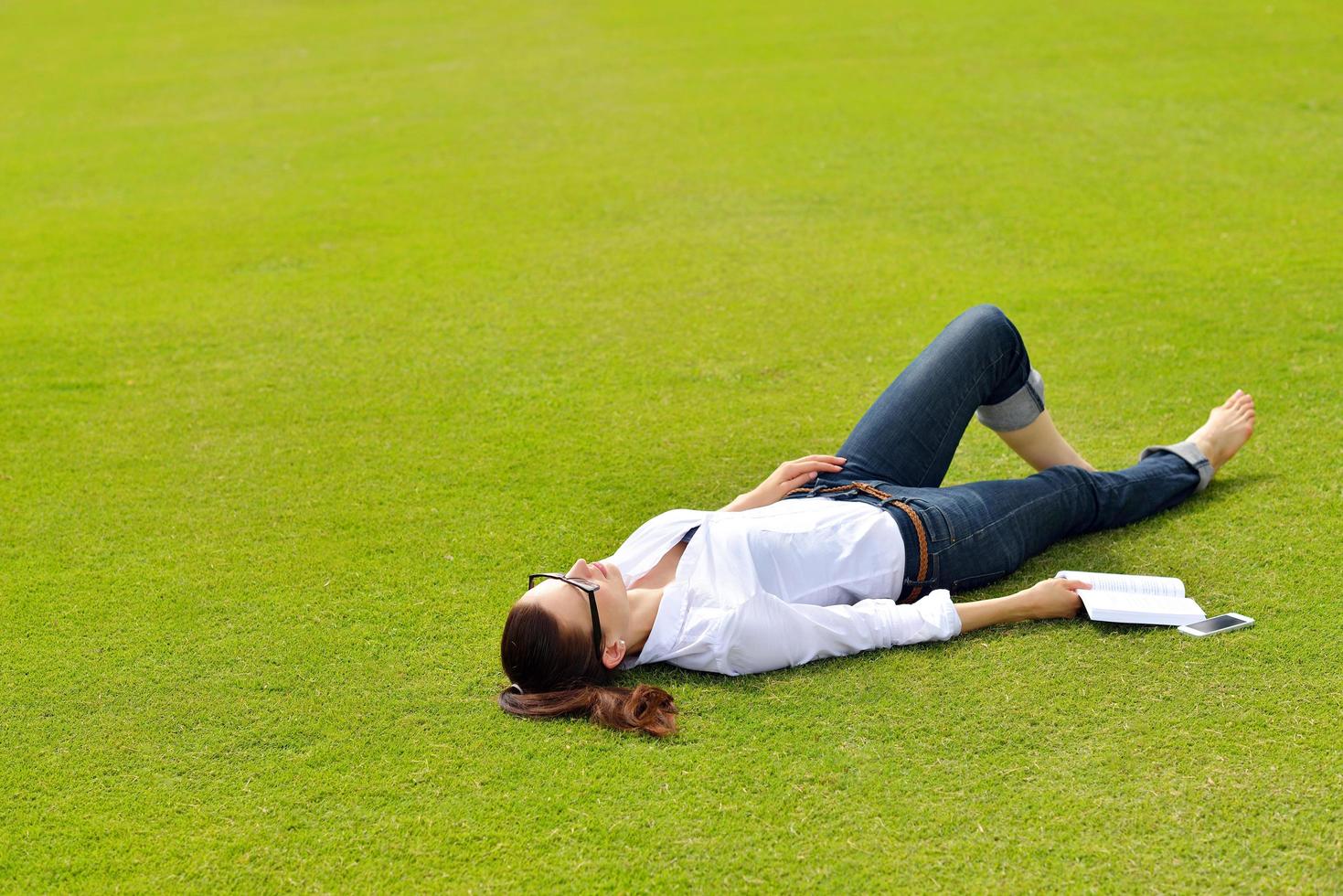 mujer joven leyendo un libro en el parque foto