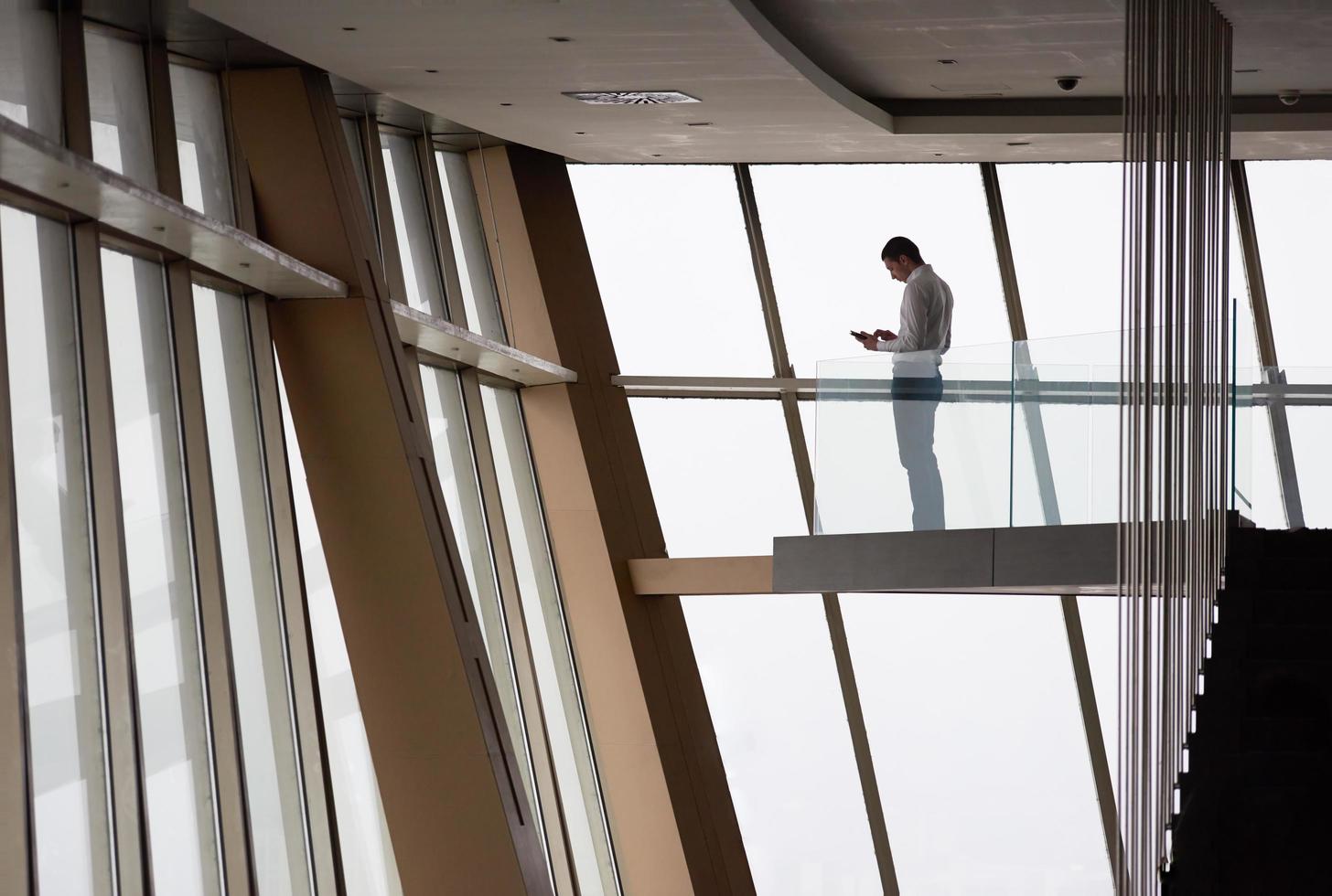 young successful business man in penthouse apartment working on tbalet photo