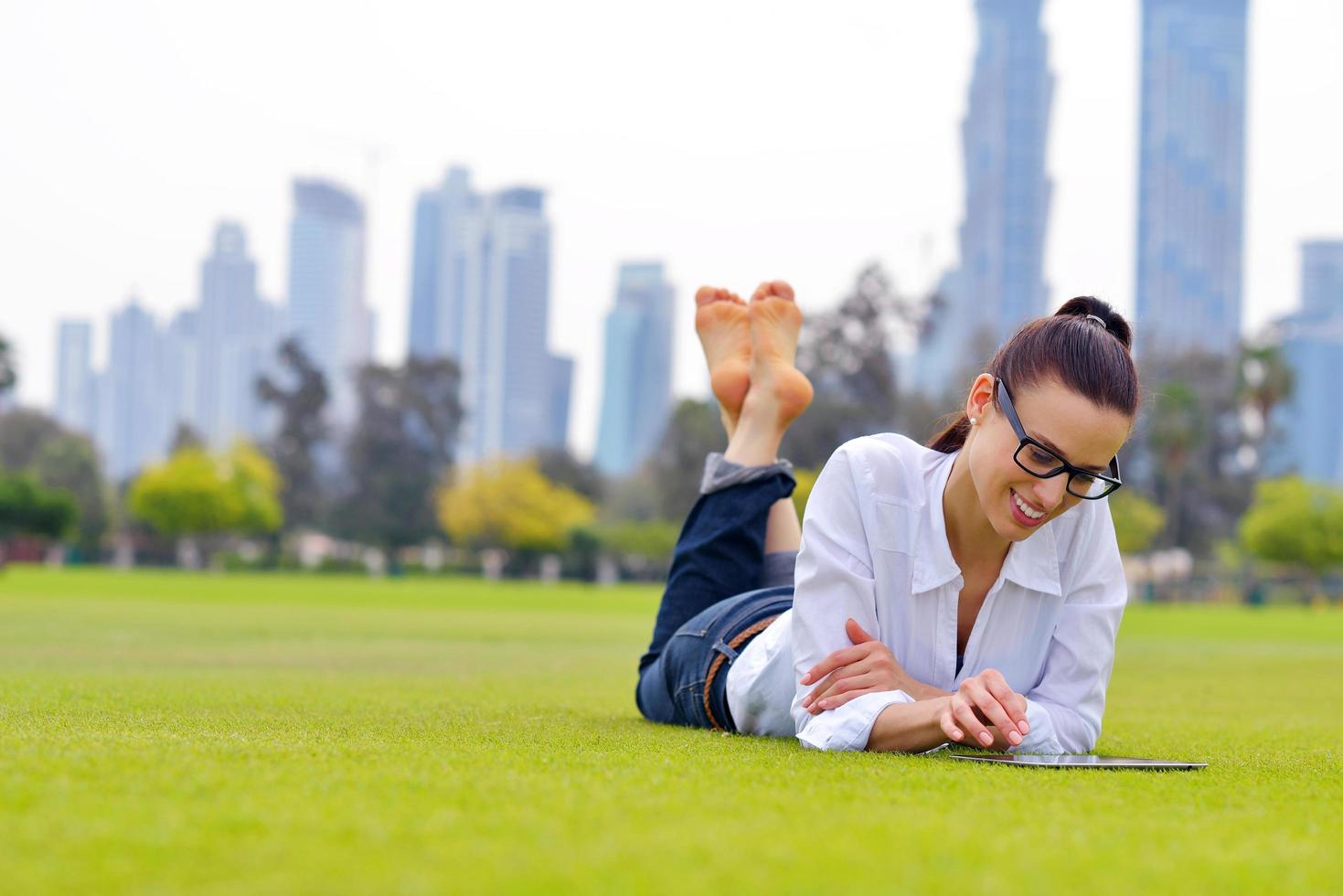 Beautiful young woman with  tablet in park photo