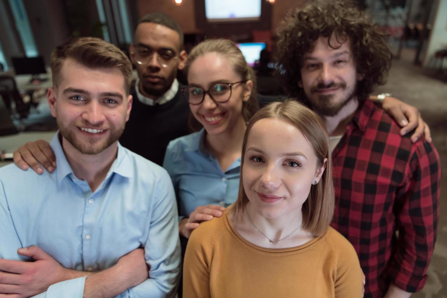 Group of business people during break from the work taking selfie picture while enjoying free time in relaxation area at modern open plan startup office. Selective focus photo