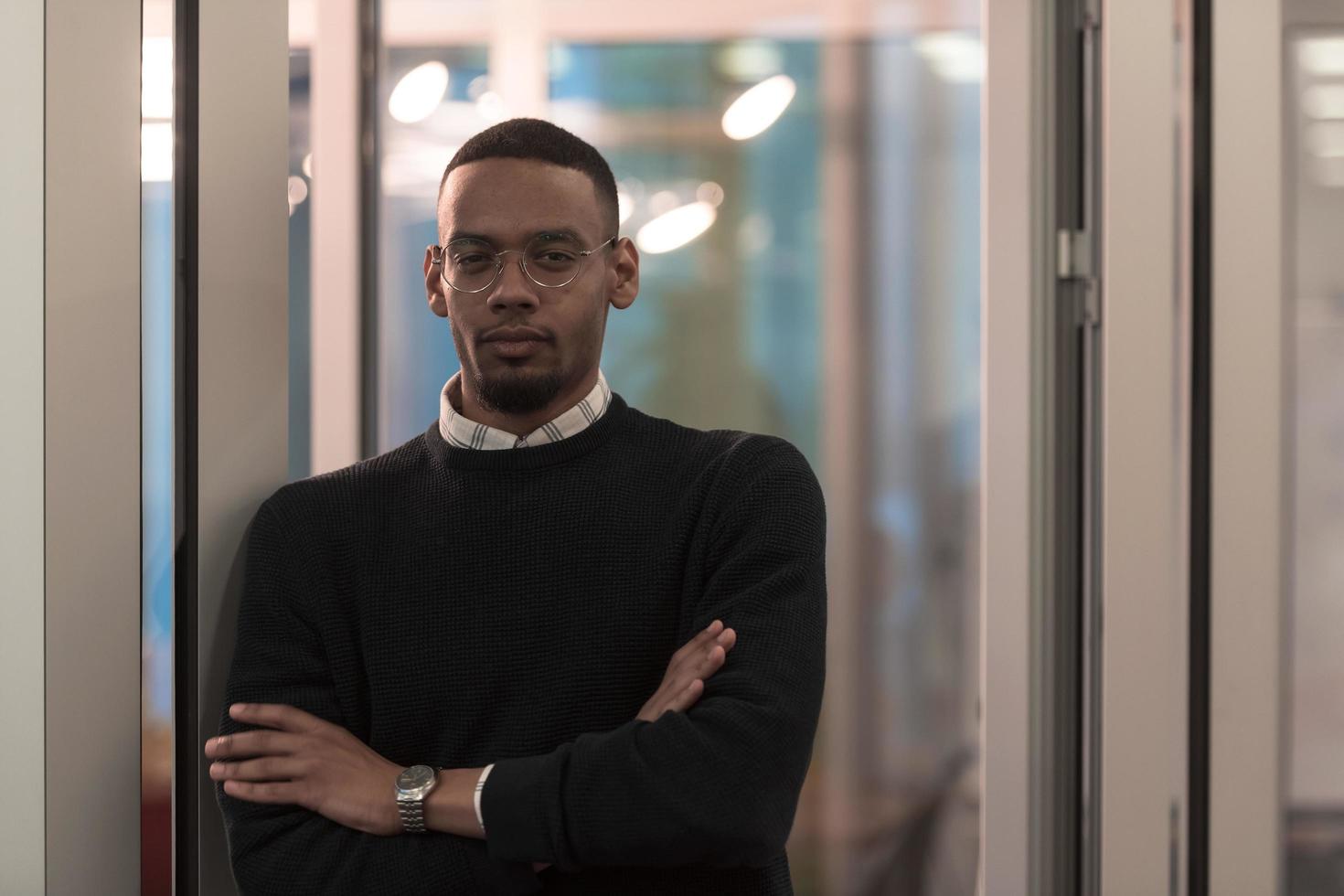African American man looking at camera standing in office lobby hall. Multicultural company managers team portrait. photo