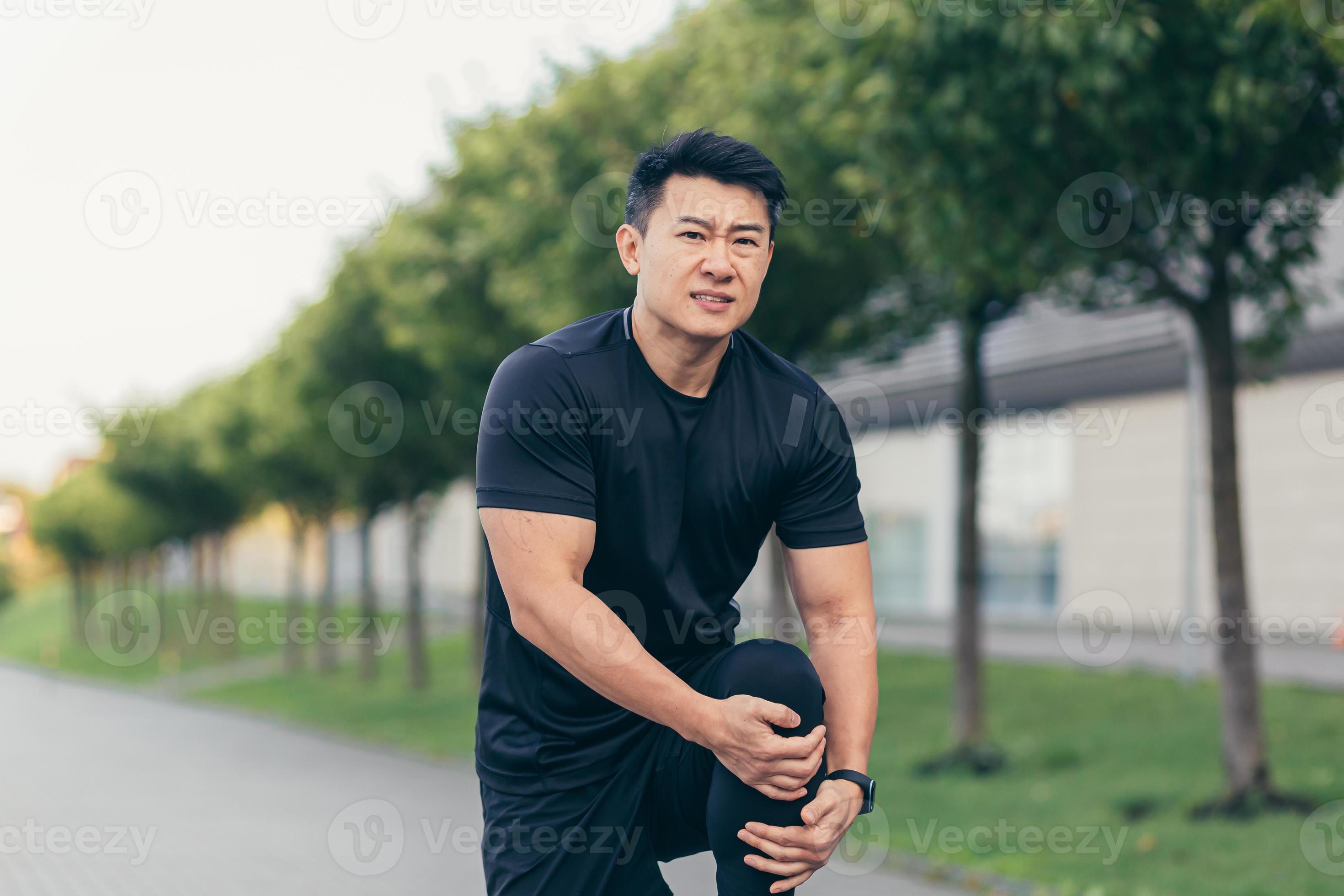 Asian man holding knee pain after running and fitness, severe leg pain