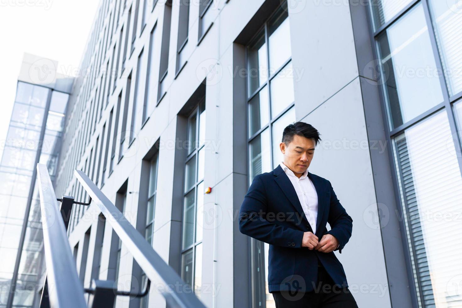 Asian businessman walks up the stairs of the office center, man hurries to a business photo