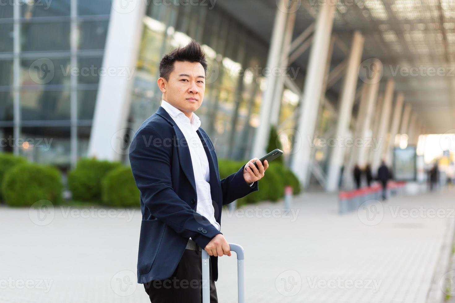 hombre de negocios tratando de llamar a un taxi usando una aplicación y un teléfono móvil, hombre asiático en el tren foto