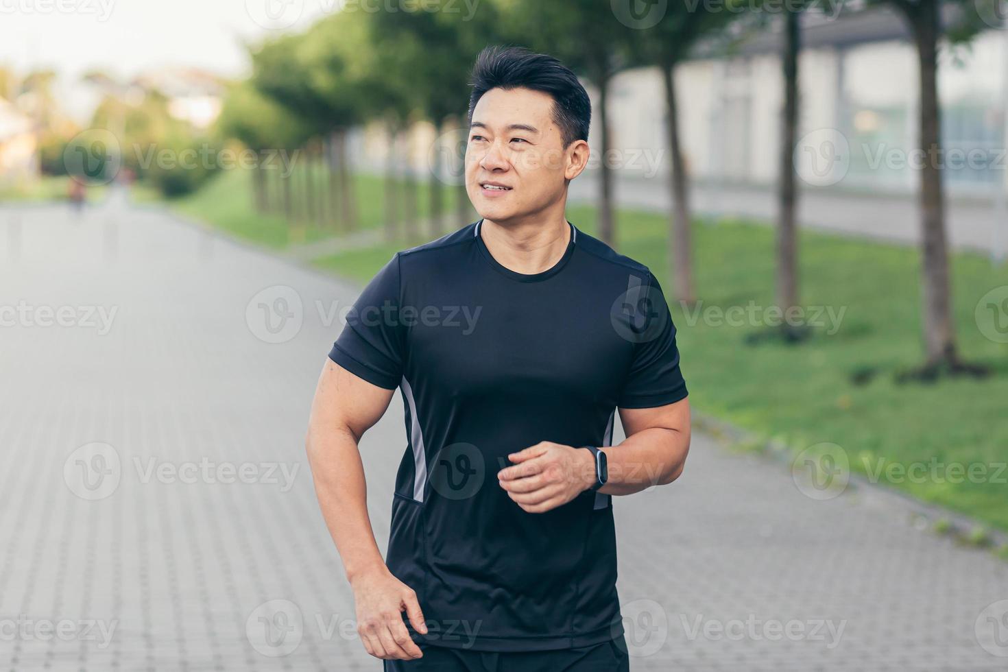 Male asian athlete running in the park in a backpack before work, running in the park photo