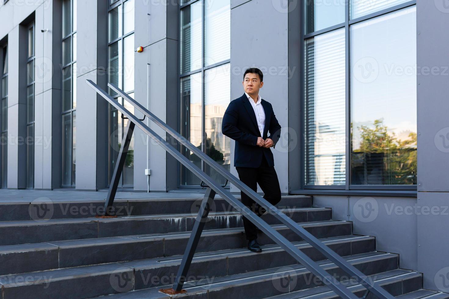 Asian businessman walks up the stairs of the office center, man hurries to a business photo