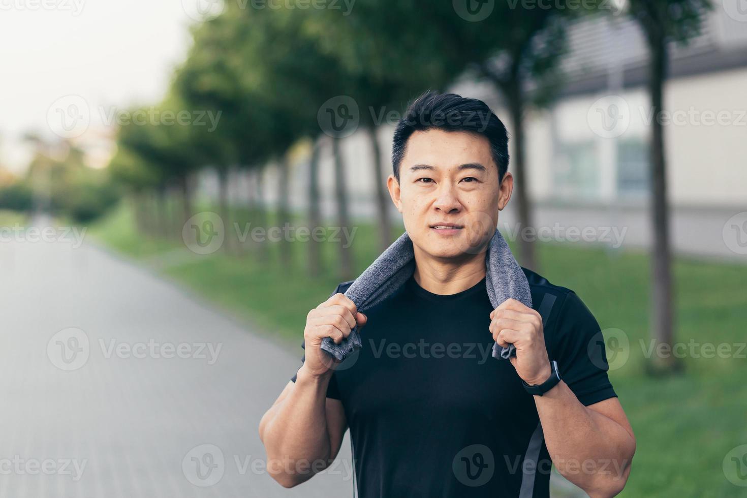 asian man after fitness workout and jogging happy man smiling shows thumb up and looks at camera photo