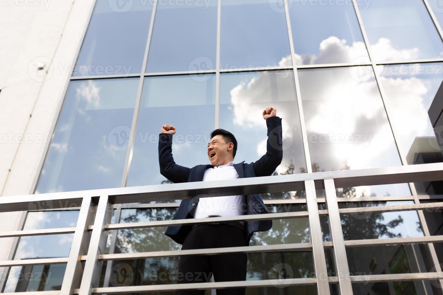 Asian businessman boss stands near his office center on the balcony in a dark color business photo