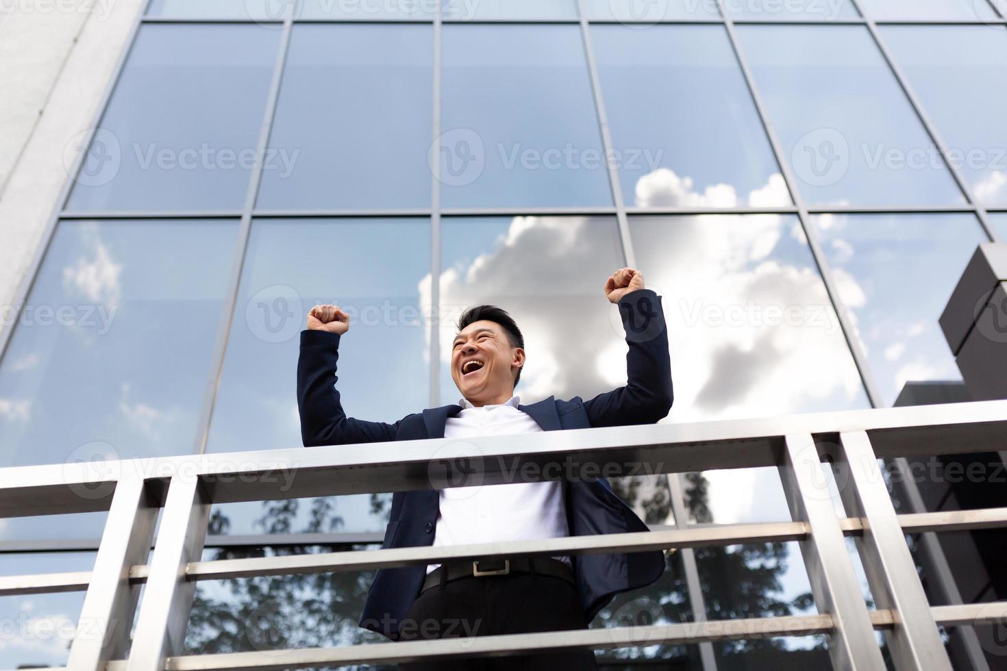 Asian businessman boss stands near his office center on the balcony in a dark color business photo