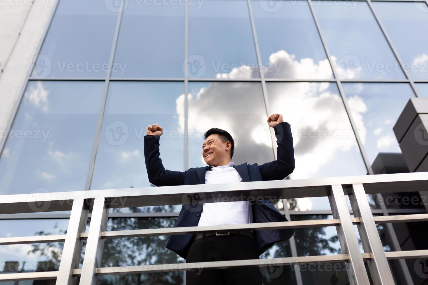Asian businessman boss stands near his office center on the balcony in a dark color business photo