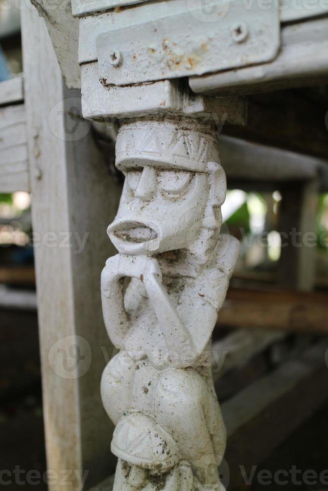 the legs of a chair with unique carvings in the form of miniature humans photo