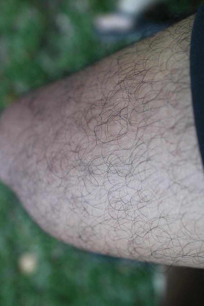 the skin texture of a man's feet is brown full of fur photo