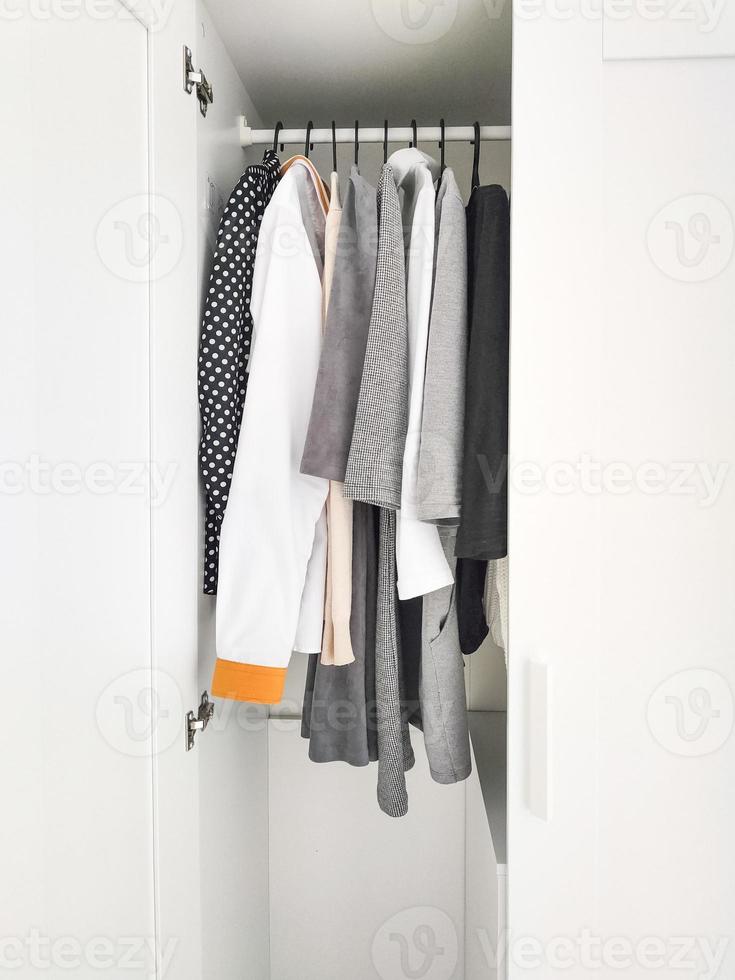 Wardrobe with basic clothes in room scandi interior. photo