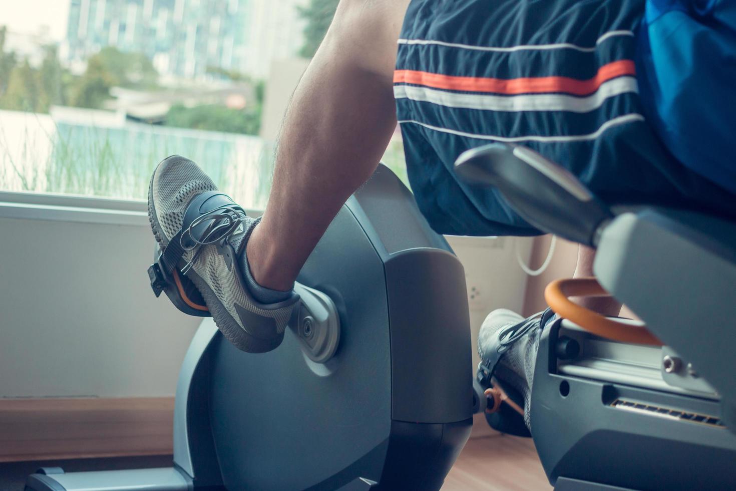 Young man using a exercise bike in an indoor fitness center photo