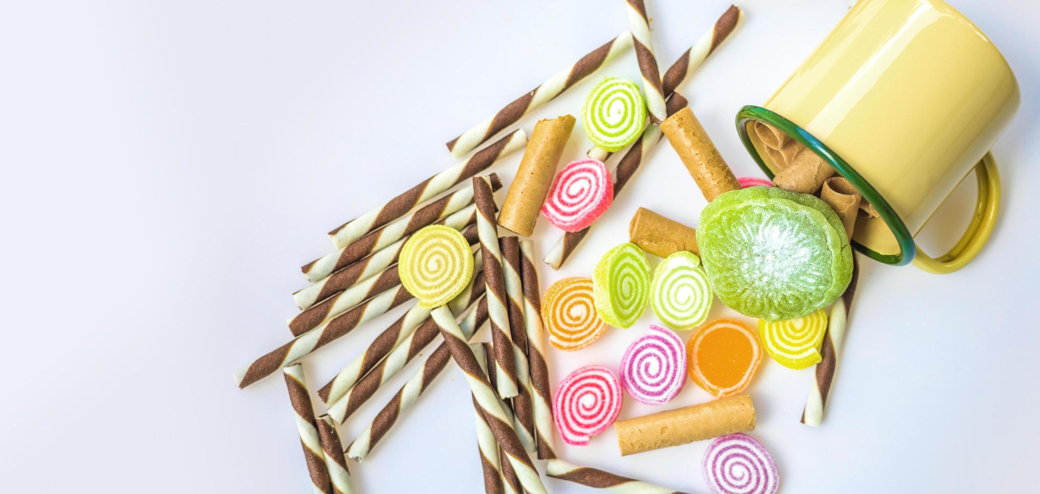 dulces coloridos y caramelos de azúcar en un fondo blanco foto