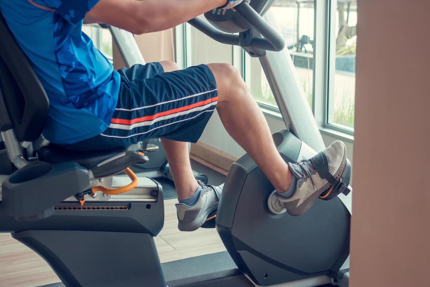 Young man using a exercise bike in an indoor fitness center photo