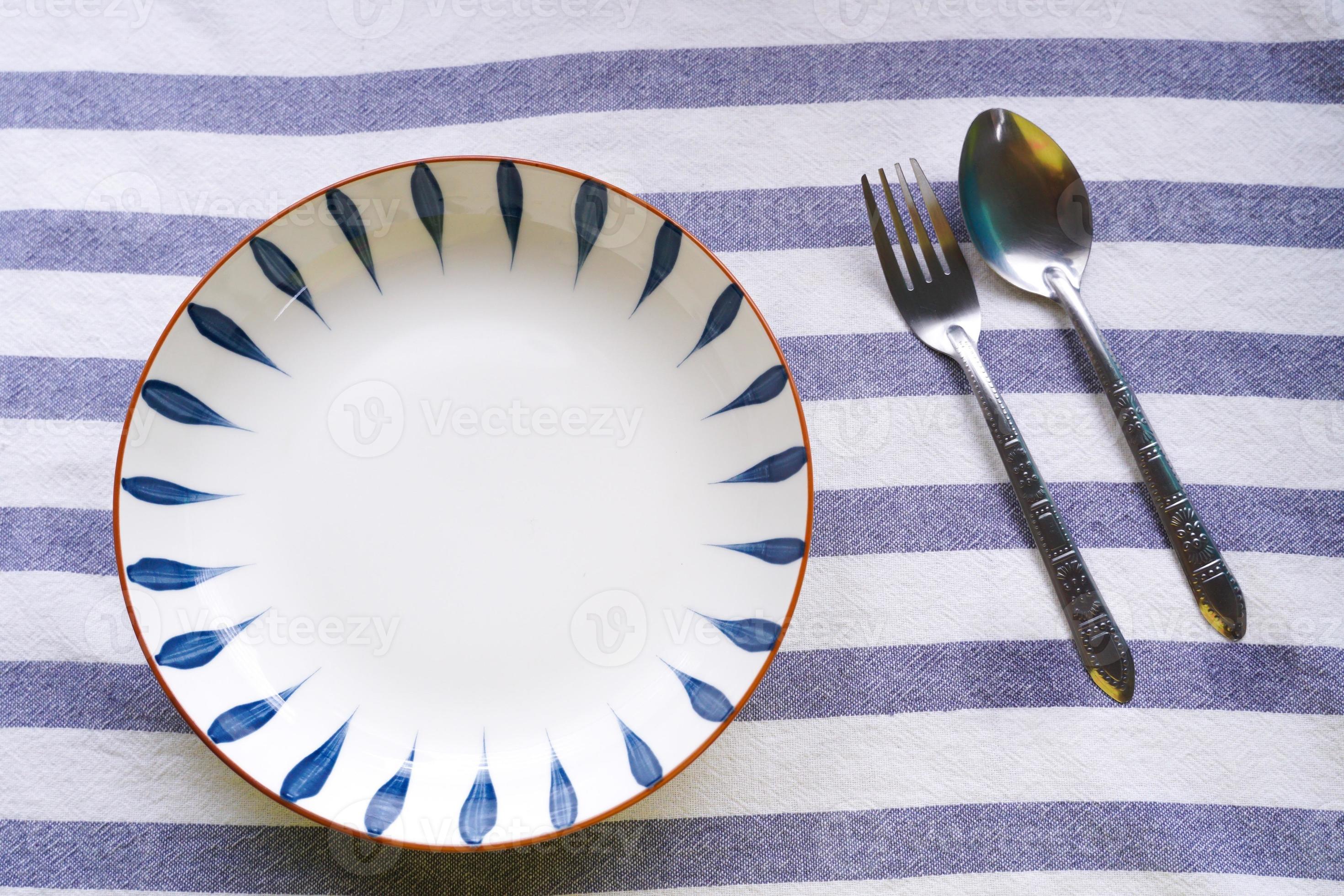 Plates and cutlery placed on a striped floor. 12498309 Stock Photo at