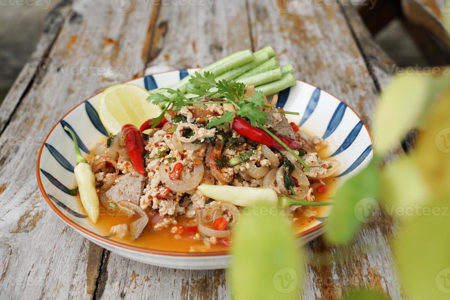 Spicy minced pork salad served with fresh vegetables Minced pork salad is a popular traditional Thai food of Thailand. Spicy Minced Pork Salad is also called Larb Moo. photo