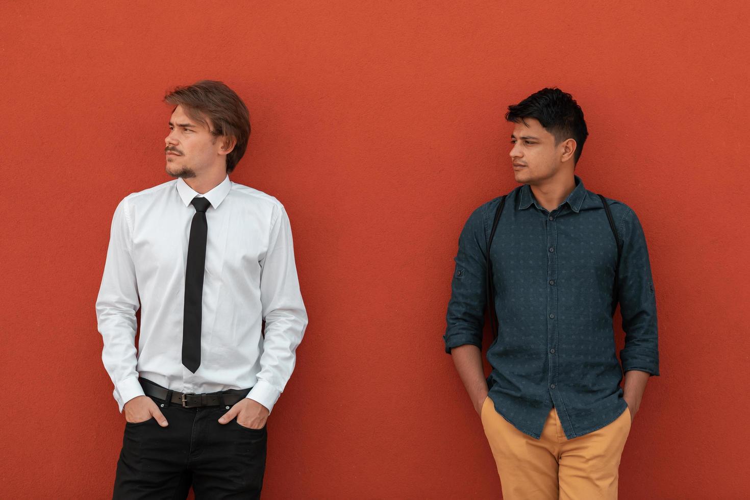 Casual multiethnic startup business men during break from work in front of red wall outside photo