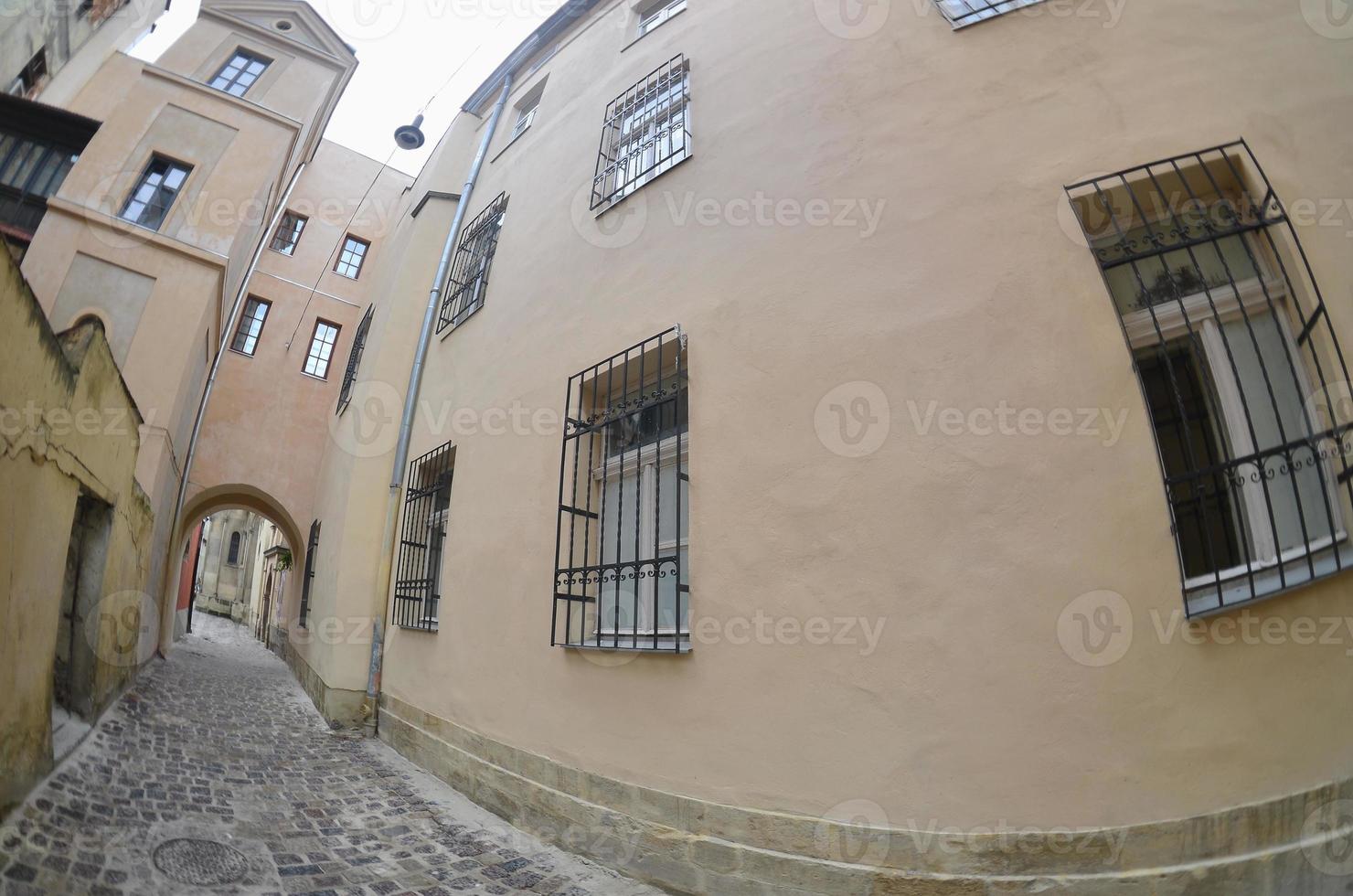 Narrow street with a path of paving stones. Passage between the old historical high-rise buildings in Lviv, Ukraine photo