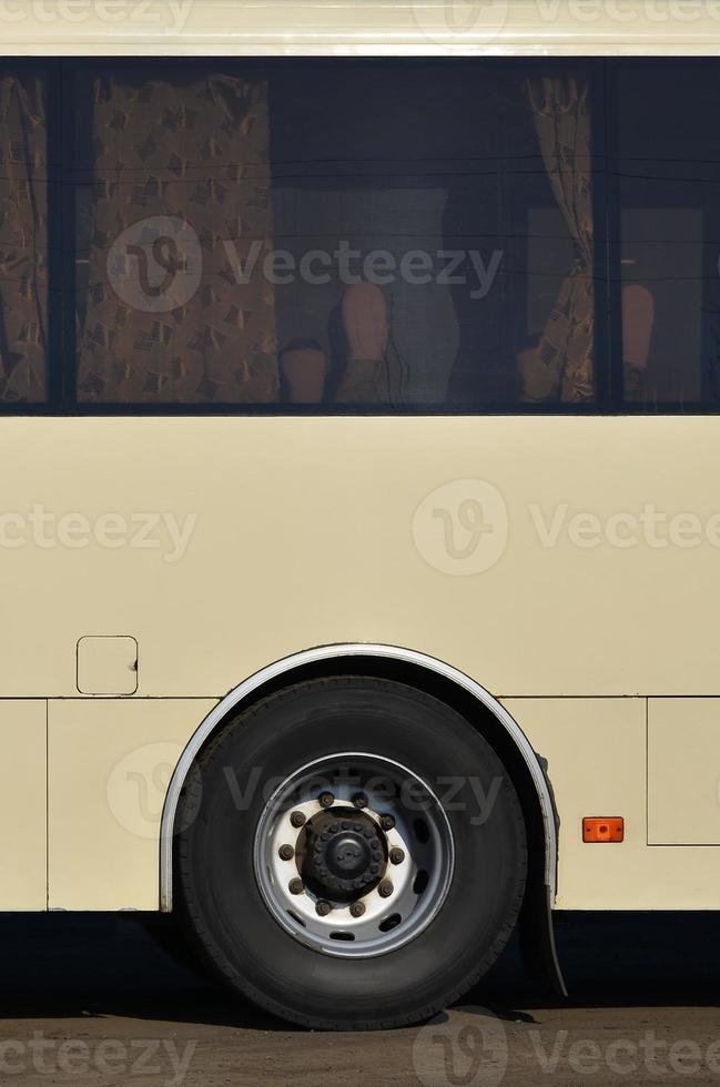 Photo of the hull of a large and long yellow bus with free space for advertising. Close-up side view of a passenger vehicle for transportation and tourism