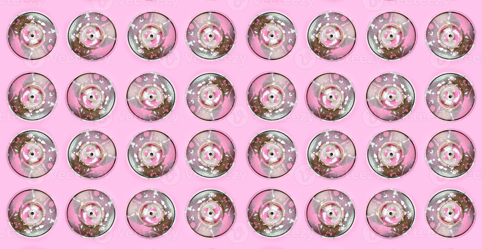 Many used spray cans for graffiti drawing lies on a pastel colored backgroung. Street art painting concept. Minimal flat lay pattern. Top view photo