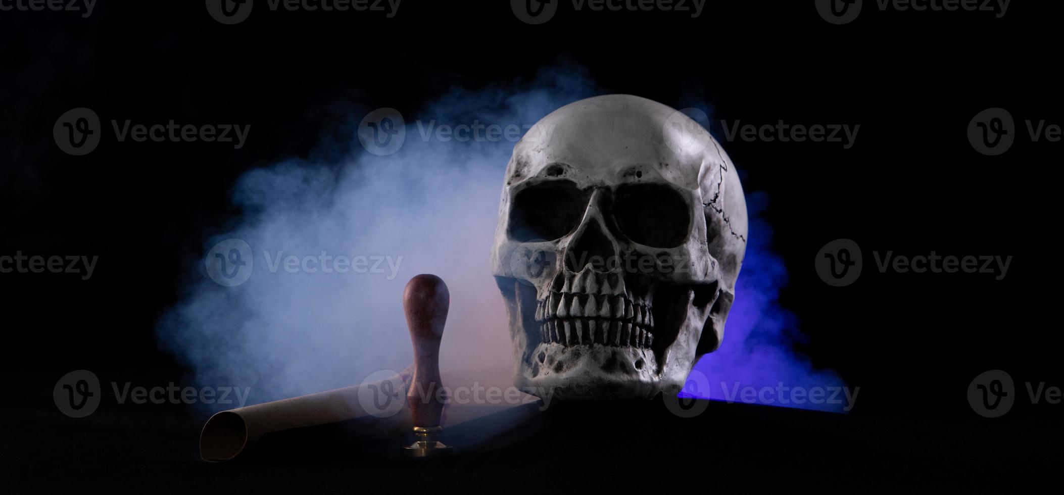 Halloween human skull on an old wooden table over black background. Shape of skull bone for Death head on halloween festival which show lastwill letter stamp interitance ghost spirit, copy space photo