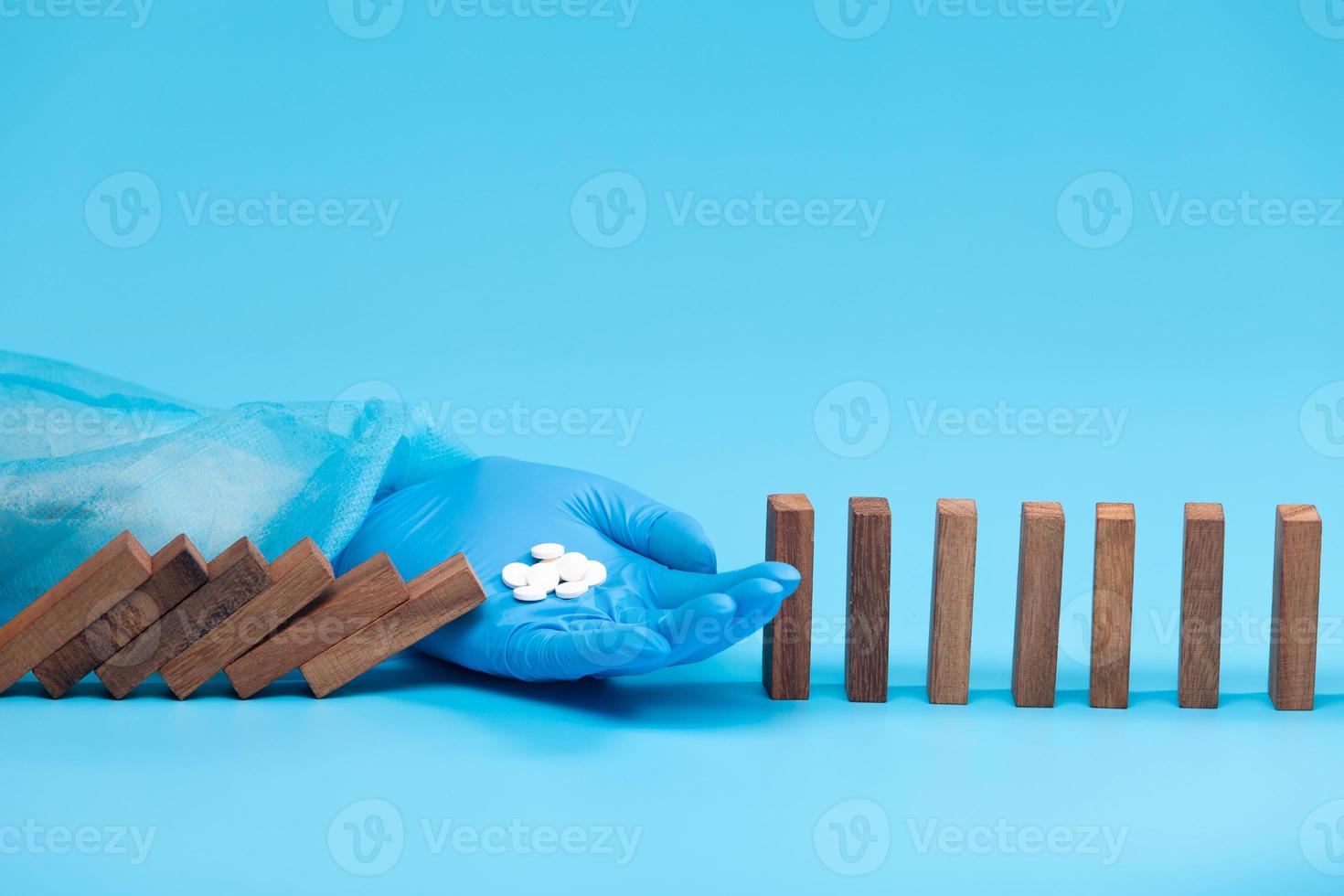 Doctor gloves give Medicine Drug Pill means stopping medical prevention of illness disease problem. Concept diagnosis check up health care plan, wooden Domino fall effect, studio blue copy space photo