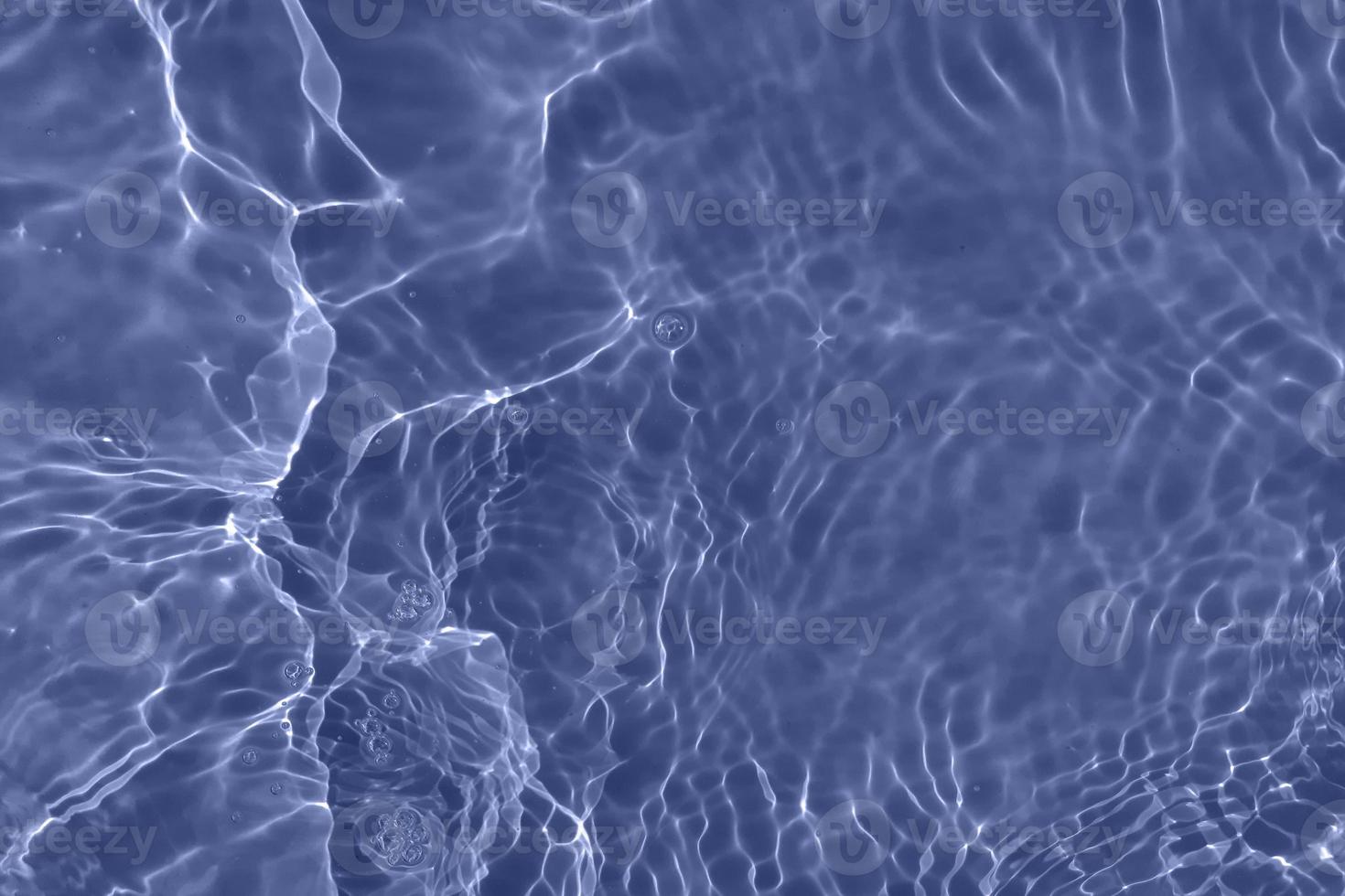 Defocus blurred transparent blue colored clear calm water surface texture with splash, bubble. Shining blue water ripple background. Surface of water in swimming pool. Blue bubble water shining. photo