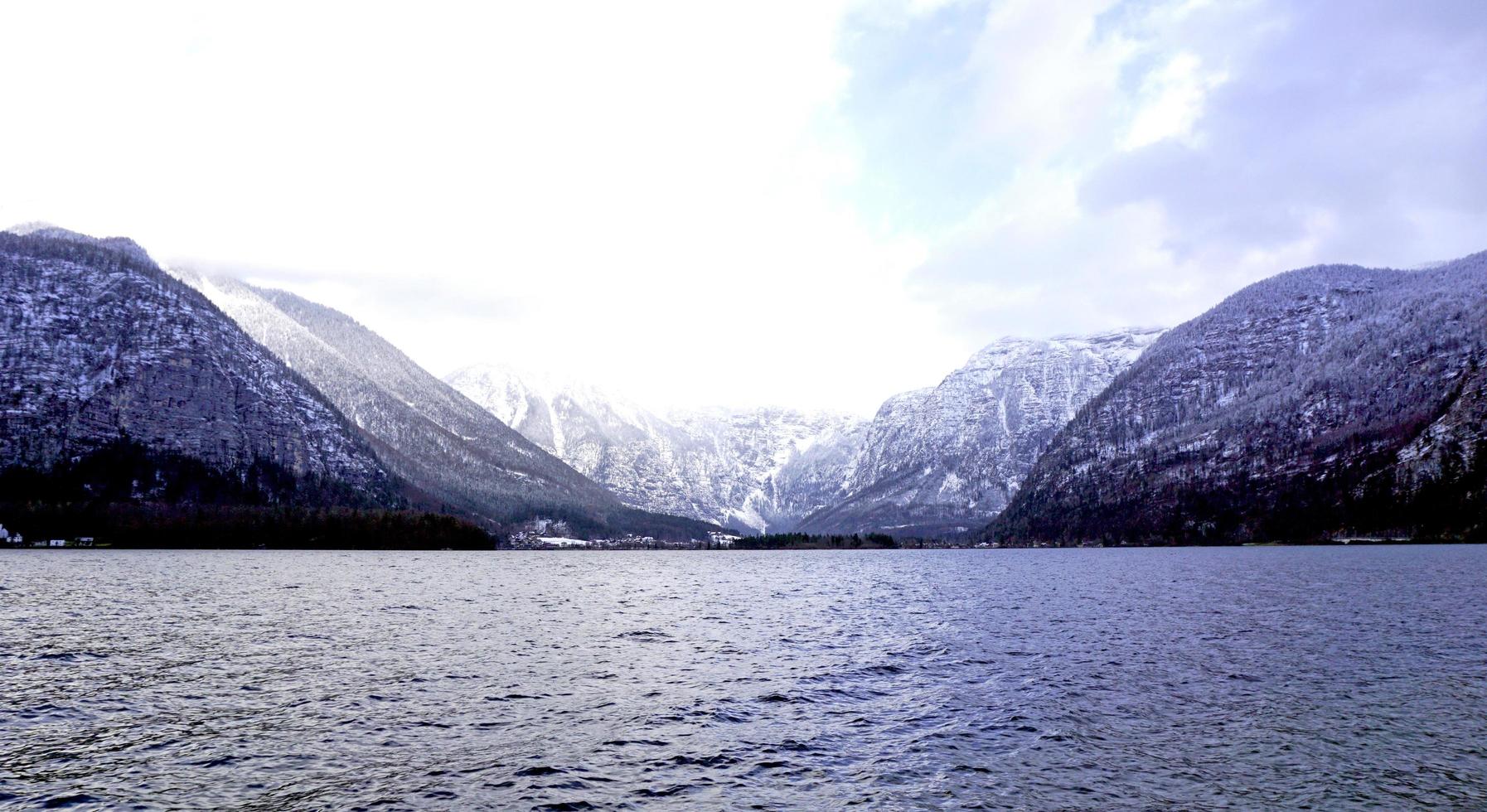 vista del lago hallstatt y campo de hierba verde al aire libre con fondo de montaña nevada en austria en los alpes austriacos foto