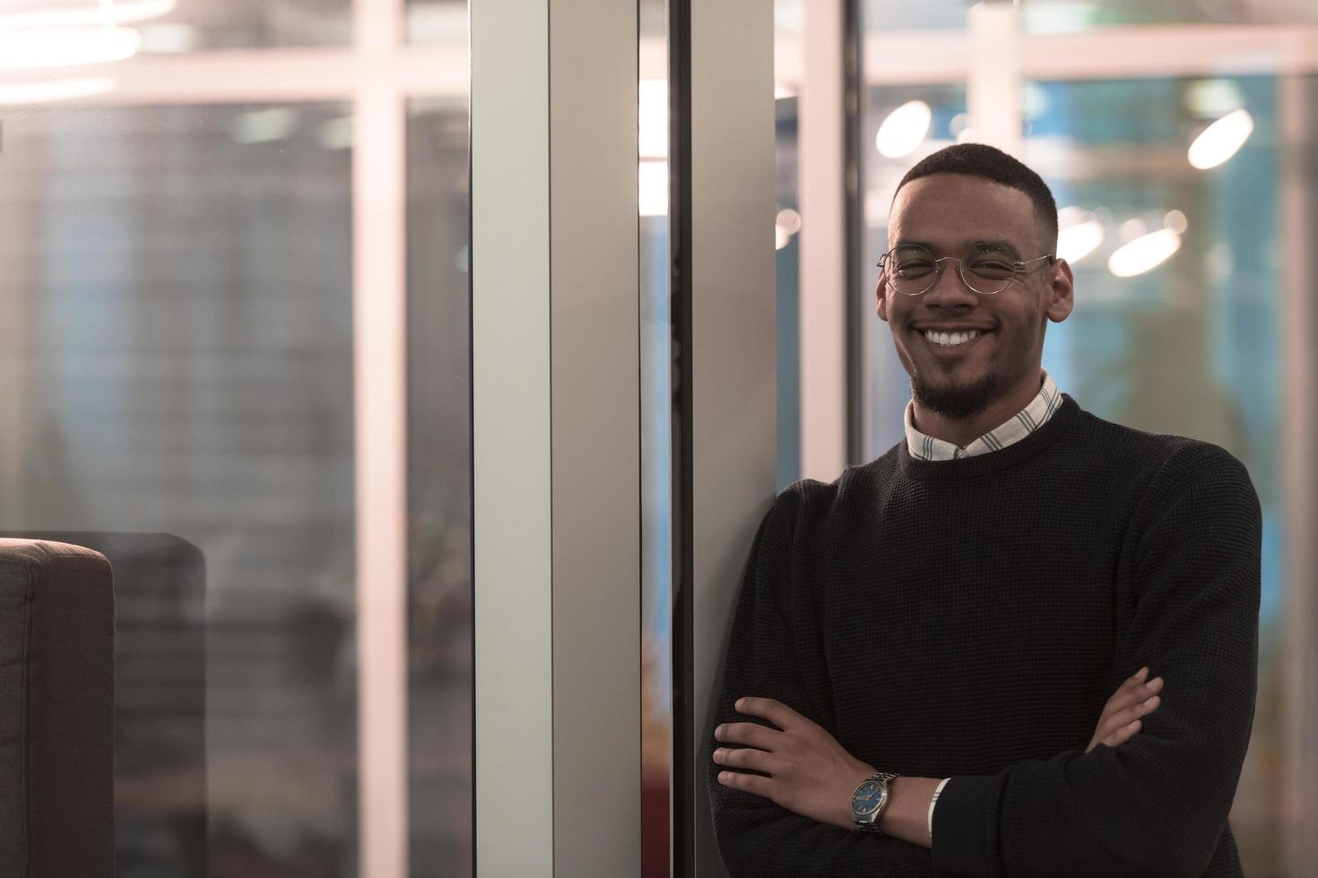 African American man looking at camera standing in office lobby hall. Multicultural company managers team portrait. photo