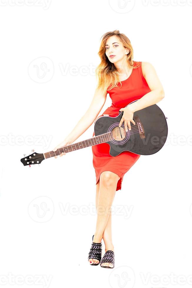 Woman dressed in red with guitar in hand on white background photo