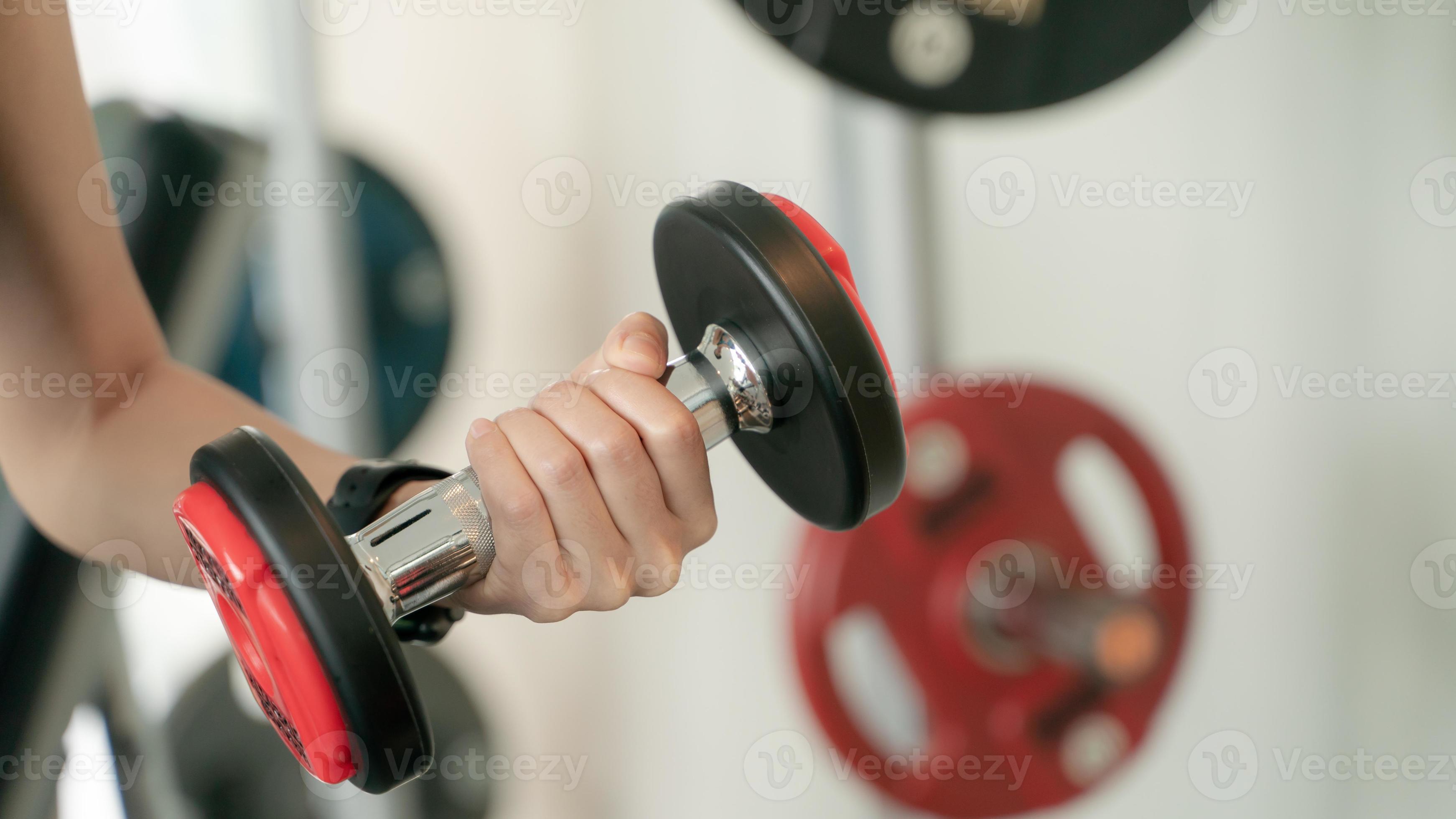 Closeup of a young woman exercising with weights in the gym. 12502326