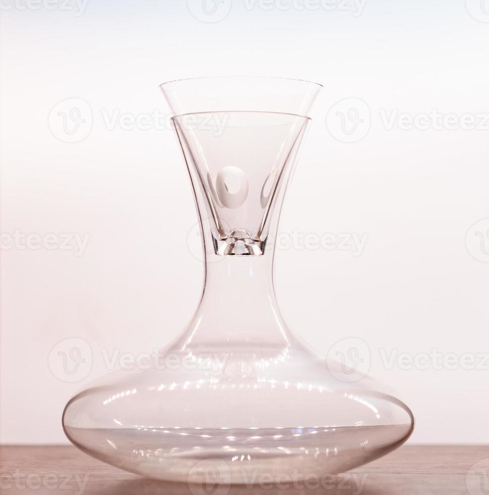 Transparent pitcher with glass on wood table with white background. photo