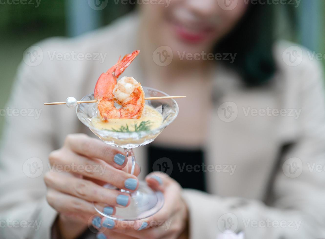 Grilled shrimp with cocktail sauce in woman hand. photo