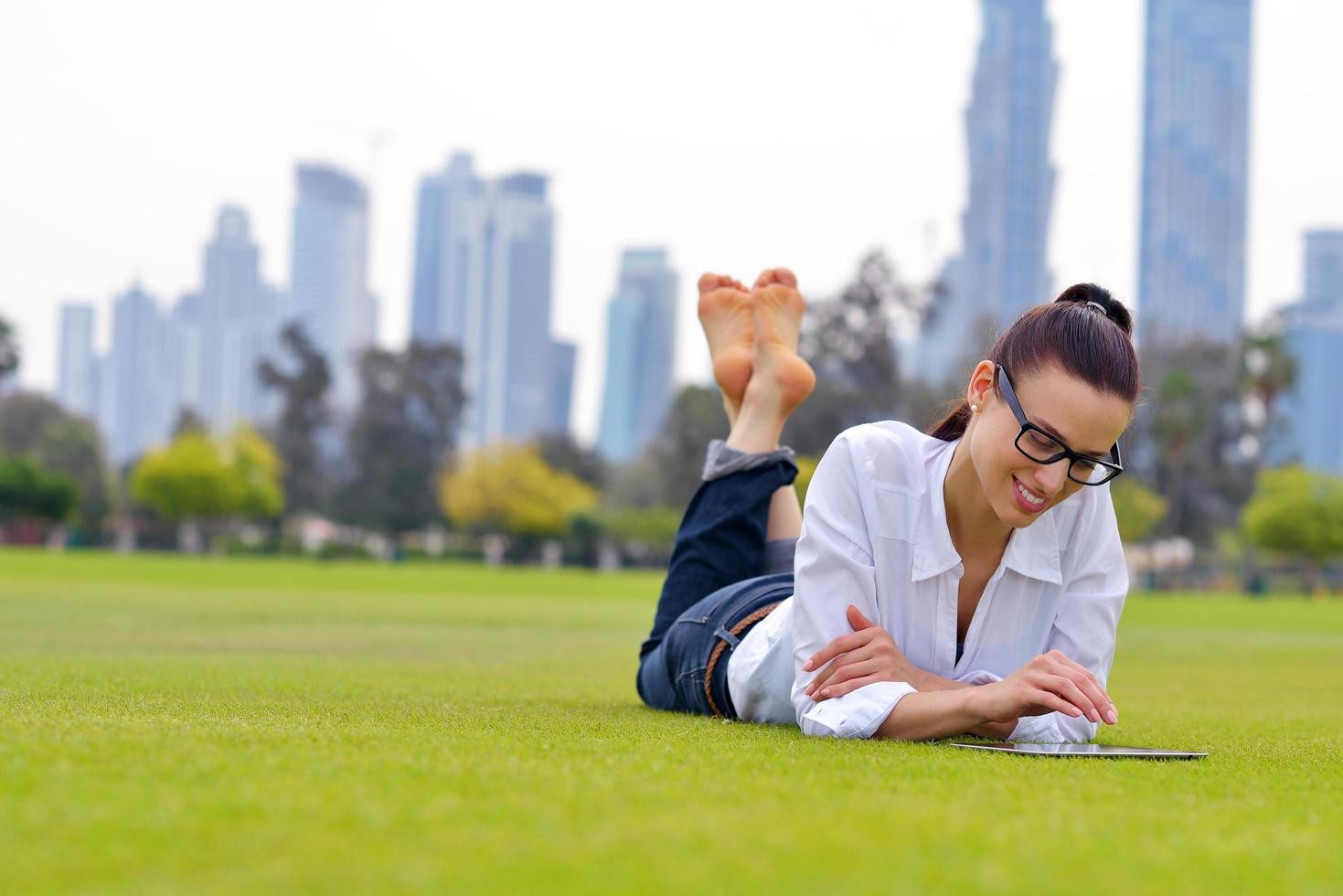 Beautiful young woman with  tablet in park photo