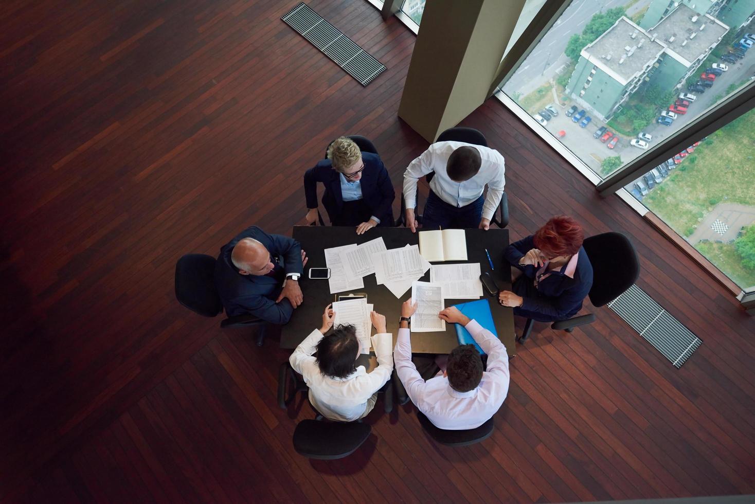 top view of business people group throwing dociments in air photo