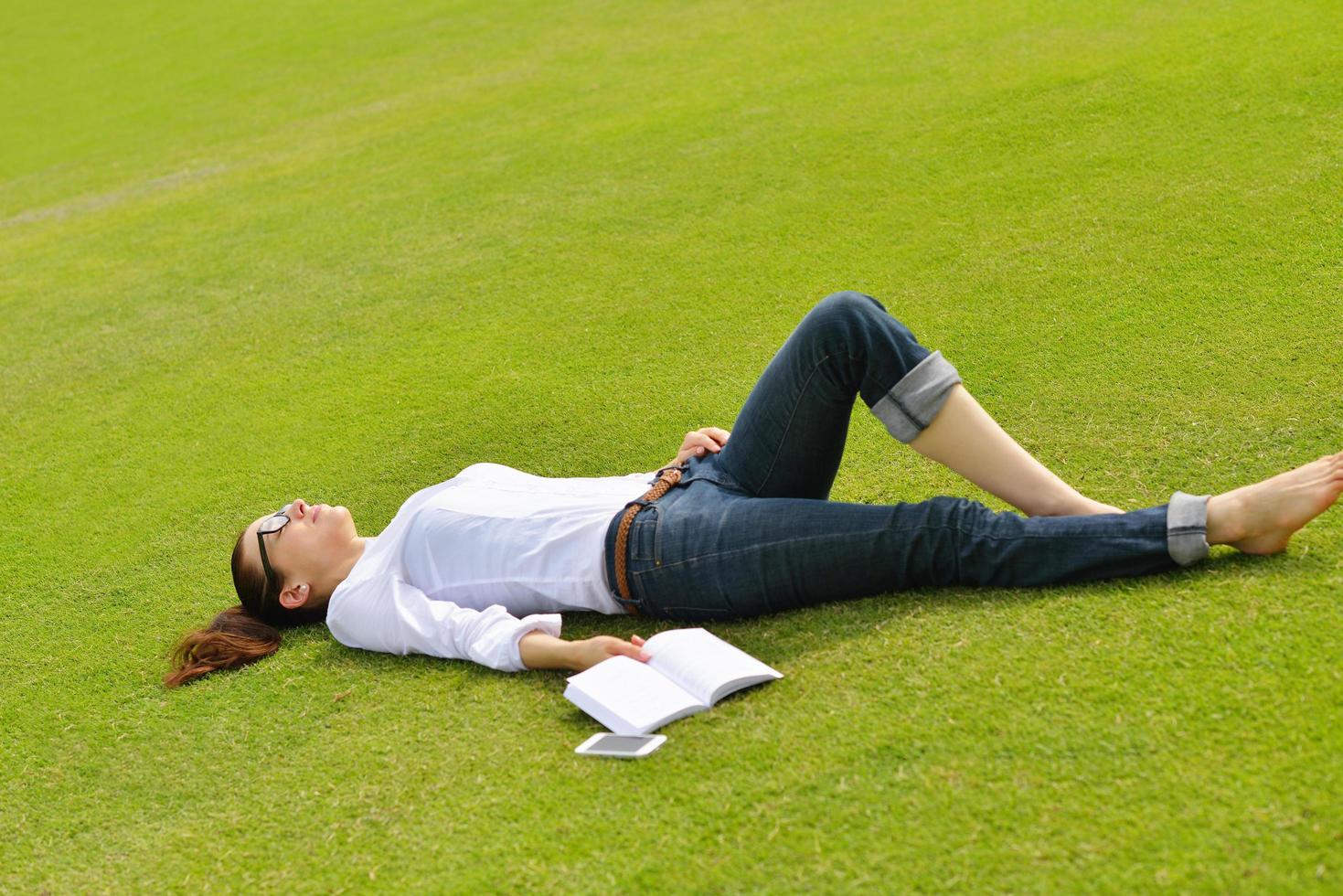 Young woman reading a book in the park photo