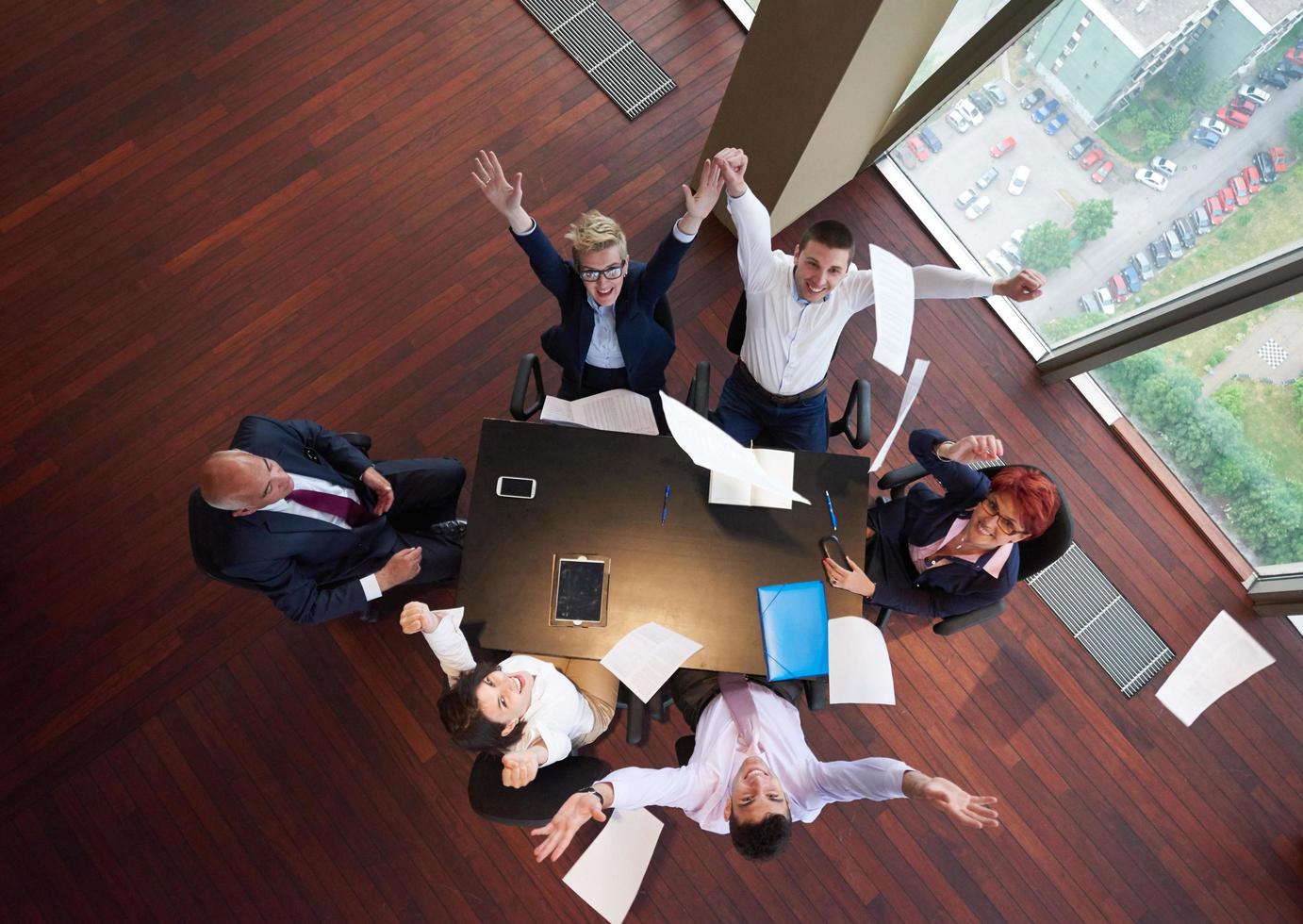 top view of business people group throwing dociments in air photo