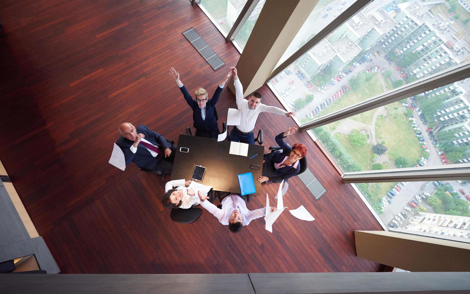 top view of business people group throwing dociments in air photo